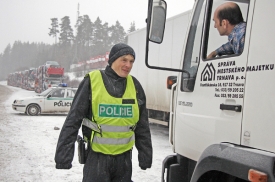 Policista diskutuje s řidičem o uzavřen&iacute; silnice.
