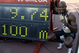 Jamajský sprinter Asafa Powell pózuje na mítinku v Rieti vedle tabule s hodnotou nového světového rekordu v běhu na 100 metrů.