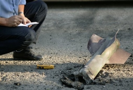 Izraelský policista prohlíží raketu odpálenou z Gazy (2007).