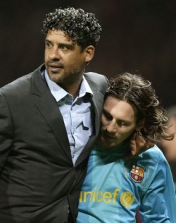 Trenér Barcelony Frank Rijkaard utěšuje Lionela Mesiiho.