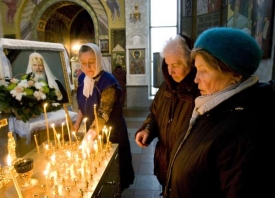 Rusové zapalují svíčky u obrazu Alexije v moskevském kostele.