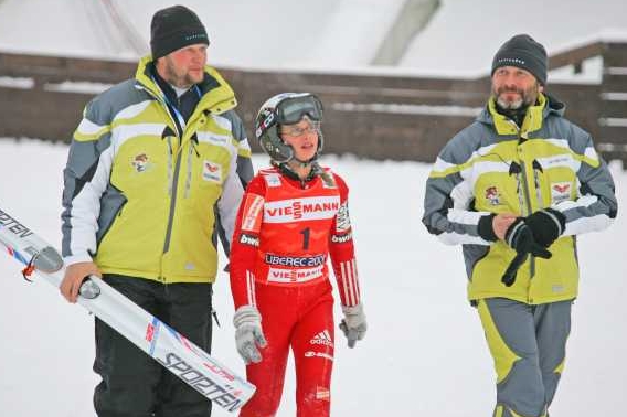 Česká skokanka Natálie Dejmková v doprovodu trenérů. Česká skokanka Natálie Dejmková v doprovodu trenérů.