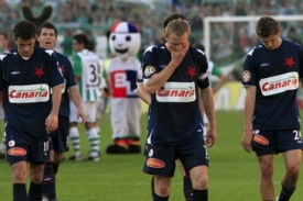 Zklamaní hráči Slavie odcházejí po prohře s Bohemians.