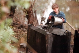 Záchranář vylévá oleje odčerpané z Černého potoka, Ostrava 1997.