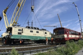 Technici odstraňují havarovanou lokomotivu.