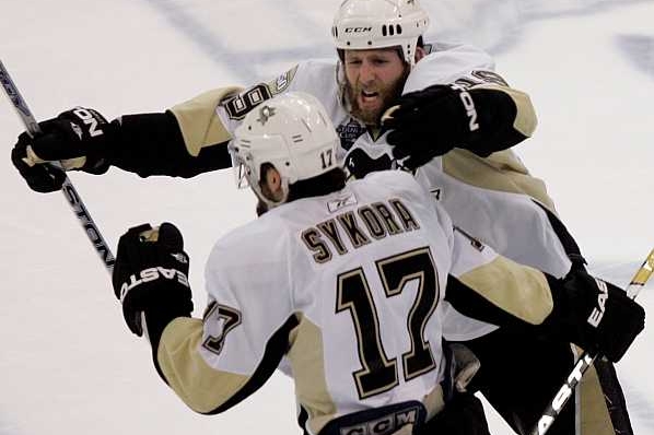 Ryan Whitney se radostí sápe na střelce Petra Sýkoru.