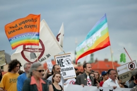 Nad průvodem demonstrantů vlály duhové vlajky a prapory Ne základnám.