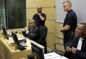 Charles Taylor (sedí vlevo) v soudní místnosti