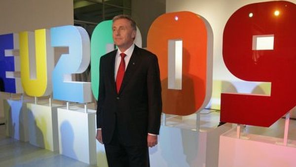 Mirek Topolánek před logem symbolizující české předsednictví EU