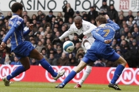 Darren Bent střílí skrz obránce Portsmouthu.