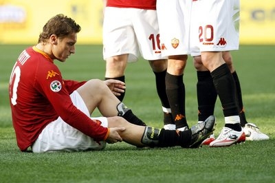 Francesco Totti zkoumá poraněnou nohu. Francesco Totti zkoumá poraněnou nohu.