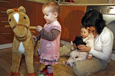Jaroslava Trojanová s Nikolkou v náručí a Verunkou doma v Jabloňově.