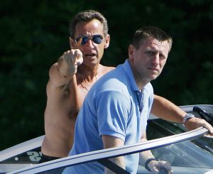 Rozlícený Sarkozy  ukazuje na forografa